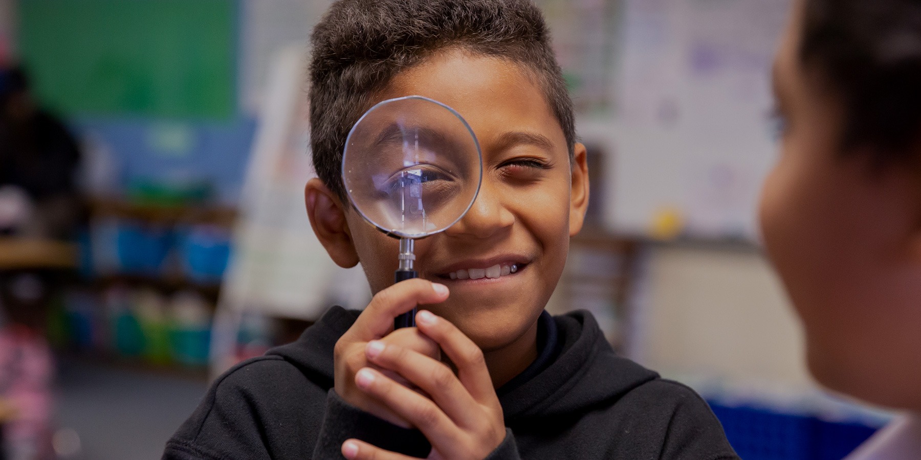 Smiling Student with Magnifying Glass